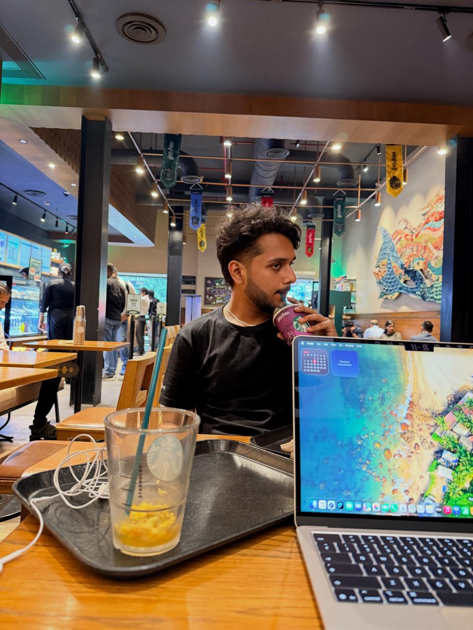 Photo of Devadi Biswas working at a café